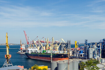 Port cargo crane loads a container onto a cargo ship in a seaport