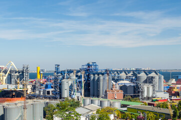 Obraz premium Granary with containers for storage and loading of grain in the seaport. Grain transportation, agribusiness
