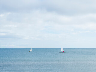 Obraz premium Dos barcos de vela en un dia tranquilo de invierno con nubes