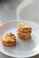 Holiday cookies in the shape of a heart, with cottage cheese cream and pistachios