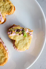 Holiday cookies in the shape of a heart, with cottage cheese cream and pistachios