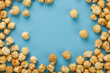 Caramel popcorn by a ripple on a blue background, in the form of a frame.