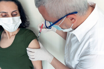 when the doctor vaccinated the woman, While the lady was getting vaccinated, vaccinating, vaccine