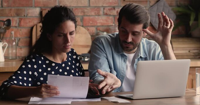 Spouses experiencing financial problem, concerned wife and husband examining family budget feel stressed due high taxes, lack of money to pay monthly household bills, bank loan, unpaid receipt concept