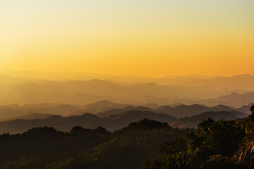 Fototapeta premium landscape in thailand sunrise on mountains peaceful with mist and sunlight at morning picturesque scenery outdoors travel.