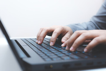 close-up of business woman hand typing and using laptop keyboard for searching with technology networking on working and job on desk at work place or work at home.