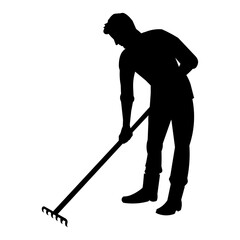 Silhouette of a man weeding the garden with a rake and takes care of the plant