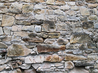 Texture with stacking sandy cobblestones. Light brownstones of different sizes. The structure of the old castle.