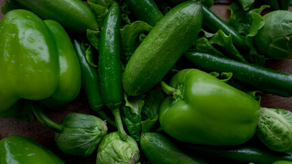 Food background. Bell green peppers, cucumbers, hot green chili peppers, Brussels sprouts, green salad.