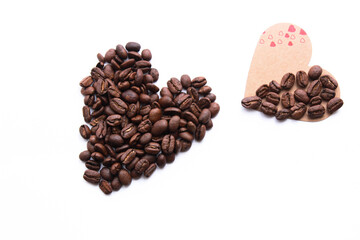 Heart shape made from coffee beans, love and coffee themed concept background photo isolated on white background. Top view, copy space for your text.