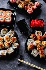 Fresh sushi rolls set on gark background