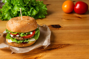 Burger with meat patty melted cheese with lettuce tomato cucumber with sauce is suitable for quick hunger quenching