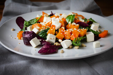 A nutritious salad for dinner lunch with pumpkin pine nuts cheese and spinach drizzled with butter and lemon juice