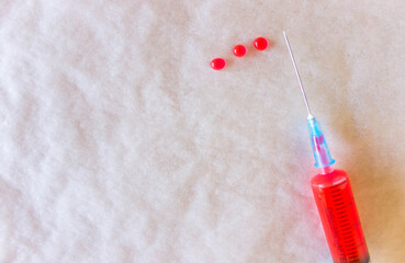 top view of syringe with red injection on white-grey background. Free copy space. Concept of medical therapy or illness.