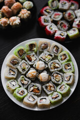 Fresh sushi rolls set on gark background