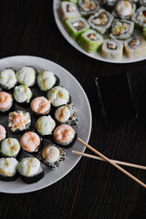 Fresh sushi rolls set on gark background