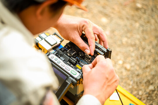Fiber Optic Fusion Splicing Cable checking signal and Wire connection with Fiber Optic Fusion Splicing machine.The technician is checking the fiber optic cable
