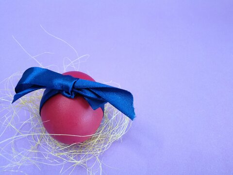 huevo rojo de pascua con cinta azul