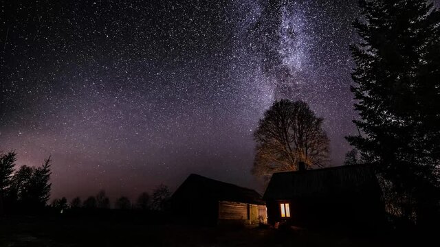 Milky way timelapse with stars in clear summer night. Old barn house. Country side. Timelapse footage.