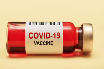 Ampoule of COVID-19 vaccine isolated on yellow background. Vial with a vaccine against the virus.