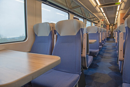 Interior of an empty commuter train carriage with seats - Powered by Adobe