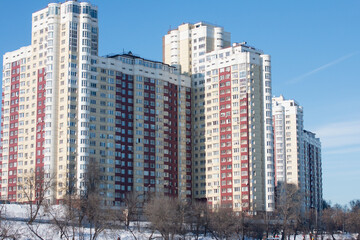 Fototapeta na wymiar multi-storey residential building in the winter park.