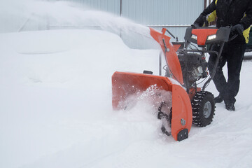 A portable snow blower powered by gasoline. Snow removal in winter.