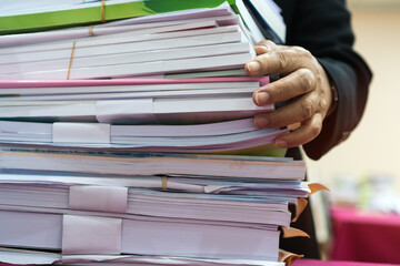 Office workers arranging stacks of lot documents report papers waiting be managed on desk in busy office. Concept of workload in business finacial paperwork information planing