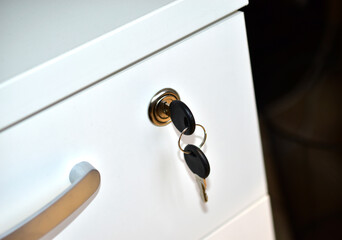 White office nightstand with a key in the lock
