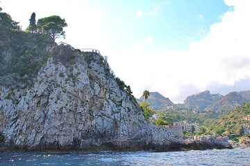 high rocky mountain descending to the sea and to the side coast and bay, houses and small hotels,...