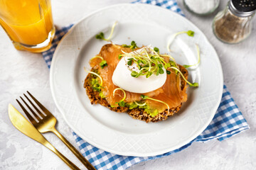 Healthy and delicious toast with avocado, salted salmon, poached egg and microgreens for breakfast or branch. Home comfort cooking. Pescatrian diet. Brain food. Omega 3 fats.