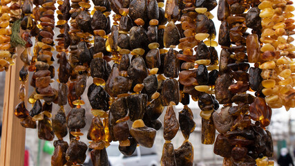 Amazing unique irregular shape natural dark orange and green necklaces made of natural amber with plant and moss inclusions  on a stall market.