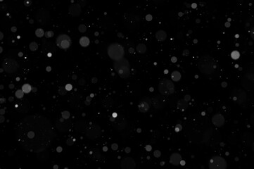 Bokeh of white snow on a black background. Snowfall - design element.