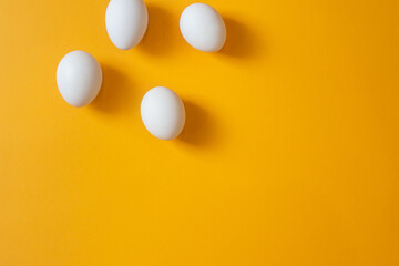 Chicken white eggs on a yellow background.