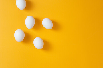 Chicken white eggs on a yellow background.