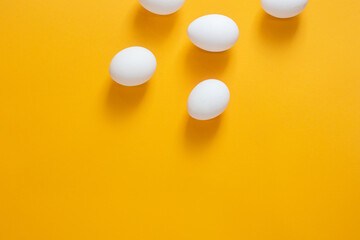 Chicken white eggs on a yellow background.