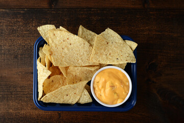 high angle view nacho chips with cheese in plastic container