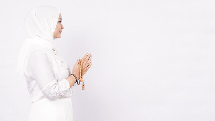 Asian muslim woman wearing prayer beads welcoming guests or Ied Fitr Greeting in white background