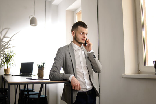 A man in  jaket in the office phone