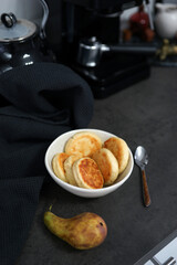 A bowl of homemade cheesecakes on a black table in the kitchen