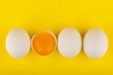 chicken eggs on yellow background top view
