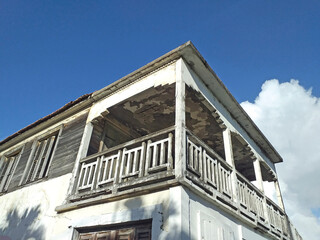 Facade corner of Caribbean building under tropical blue sky. Colonial run down house typical of the French West Indies. Architecture and Construction pattern.