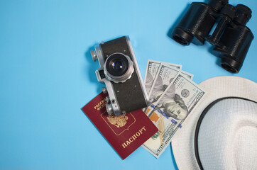 camera, binoculars, money, hat, passport lie on a blue background