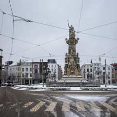 The statue of Neptune on the Marnixplaats square in the city center of Antwerp, covered in snow.