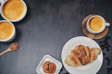 cup of coffee and Fresh baked croissant on old kitchen table. Top view with copyspace for your text.