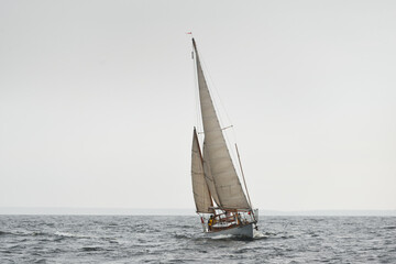 Old expensive vintage two-masted sailboat (yawl) close-up, sailing in an open sea during the storm....