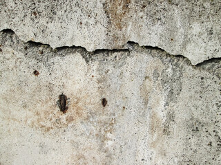 Destroyed concrete wall. The texture of the building with a crack. Pothole and flaking effect.