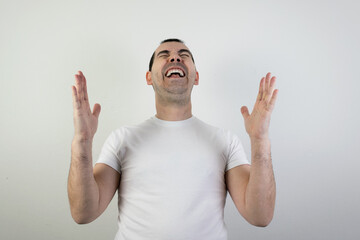 Naklejka premium happy excited young man stand white background laugh hands up crazy look angry