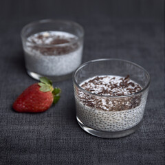 Chia pudding with chocolate shavings and strawberry on blue napkin. healthy and diet food
