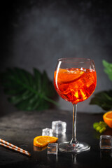 Aperol spritz cocktail in glass with fresh orange on dark background